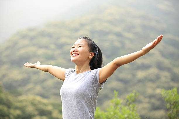 istock cheering woman open arms at mountain peak 488664909
