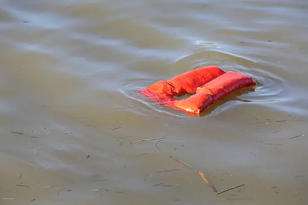 An overboard lifejacket drifting on the water.