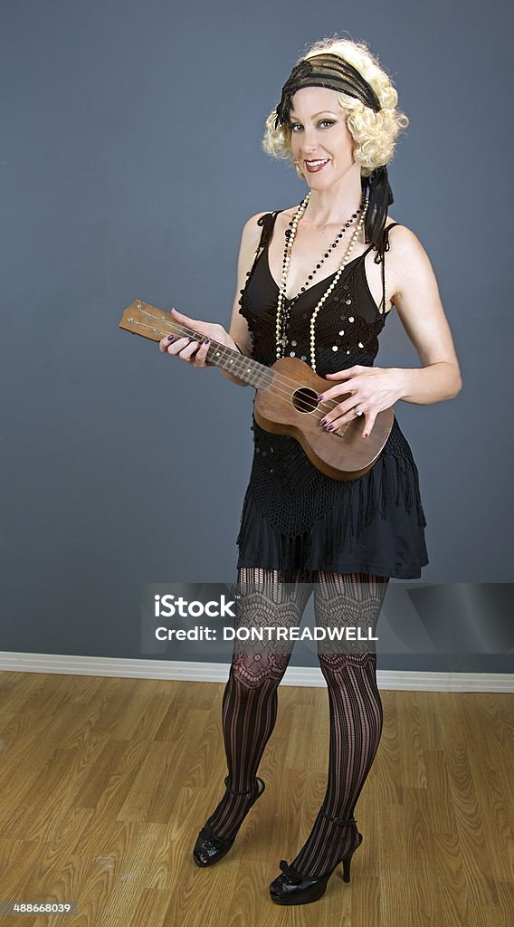 Modello femminile Strumming un ukulele - Foto stock royalty-free di 1930-1939