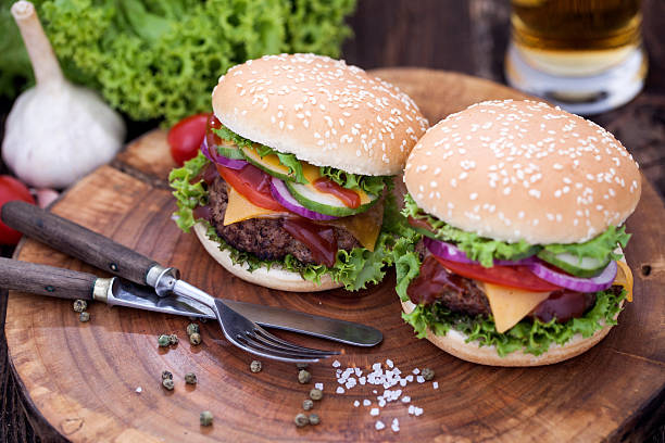 istock Beef burgers on a wooden board with chips and spices 488672484