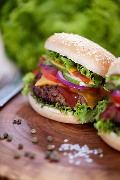 istock Beef burgers on a wooden board with chips and spices 488673668