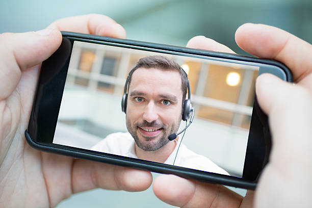 male hand holding a smartphone during a skype video stock photo