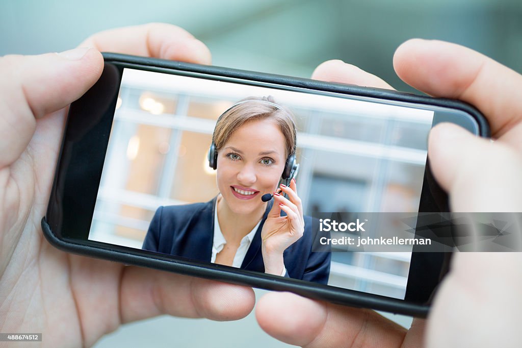 male hand holding a smartphone during a skype video Home Video Camera Stock Photo