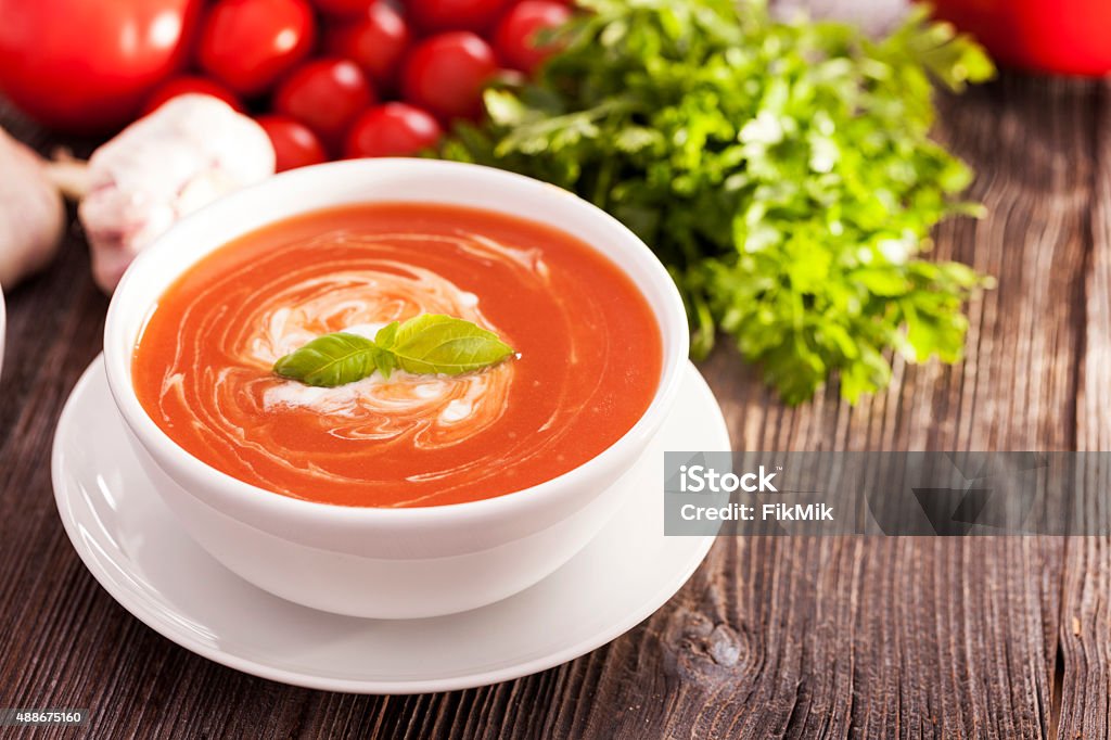 Delicious tomato soup with aromatic spices Delicious tomato soup with aromatic spices on a wooden table. Studio shot 2015 Stock Photo