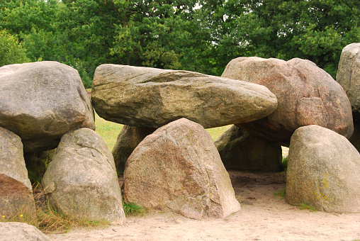 Dolmen standing infront of a tree area.