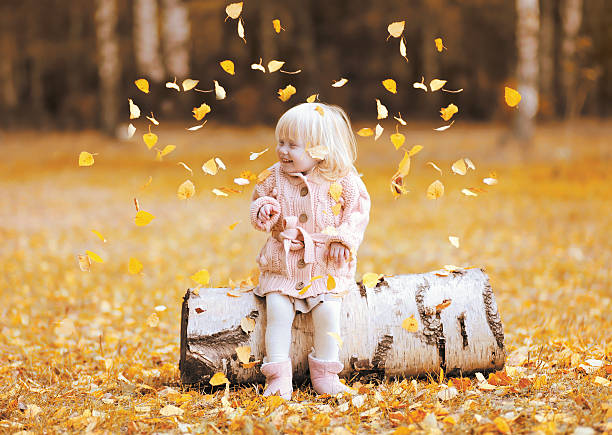 istock Happy child throws up yellow leaves and having fun autumn 488687420