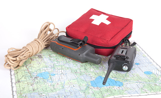 Map, gps navigator, portable radio, rope and first aid kit on a light background. Set lifeguard.