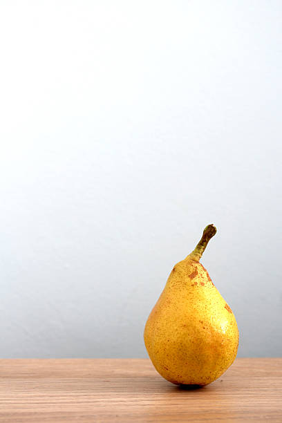Ripe pear on desk stock photo