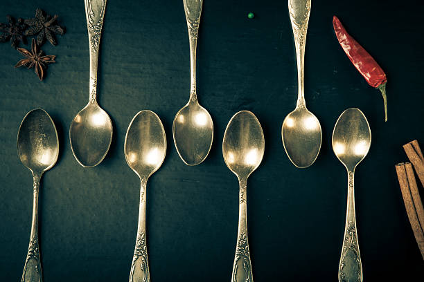istock Herbs and spices with old metal spoons on black background 488690766