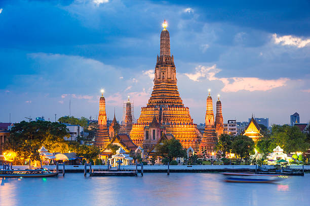 Wat Arun temple , bangkok ,thailand Wat Arun temple gold lighting after sunset with blue sky thailand pagoda stock pictures, royalty-free photos & images