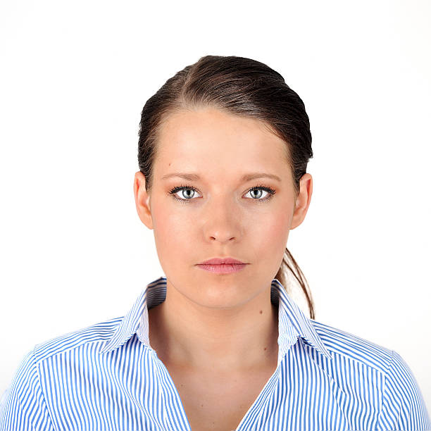 Portrait of a dark haired woman. Portrait of a woman with black hair in a pony tail, looking at the camera, against a white background. Very crisp photo with a larger depth of field. id photo stock pictures, royalty-free photos & images