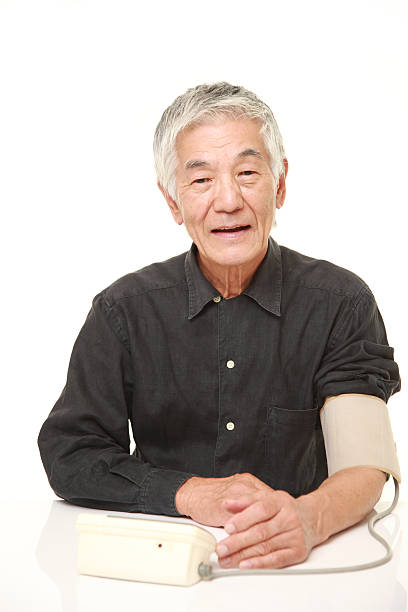 istock senior Japanese man checking his blood pressure 488693312