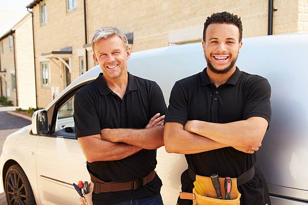 Young and a middle aged tradesman by their van Portrait of a young and a middle aged tradesman by their van craftsperson stock pictures, royalty-free photos & images