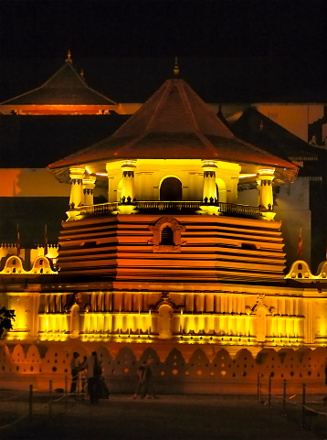 Night view of Sacred Tooth Relic Temple or Sri Dalada Maligawa which is a Buddhist temple in Kandy, Sri Lanka. It is located near the lake and there is located the tooth of Buddha under or in golden bell. It is a UNESCO world heritage site.