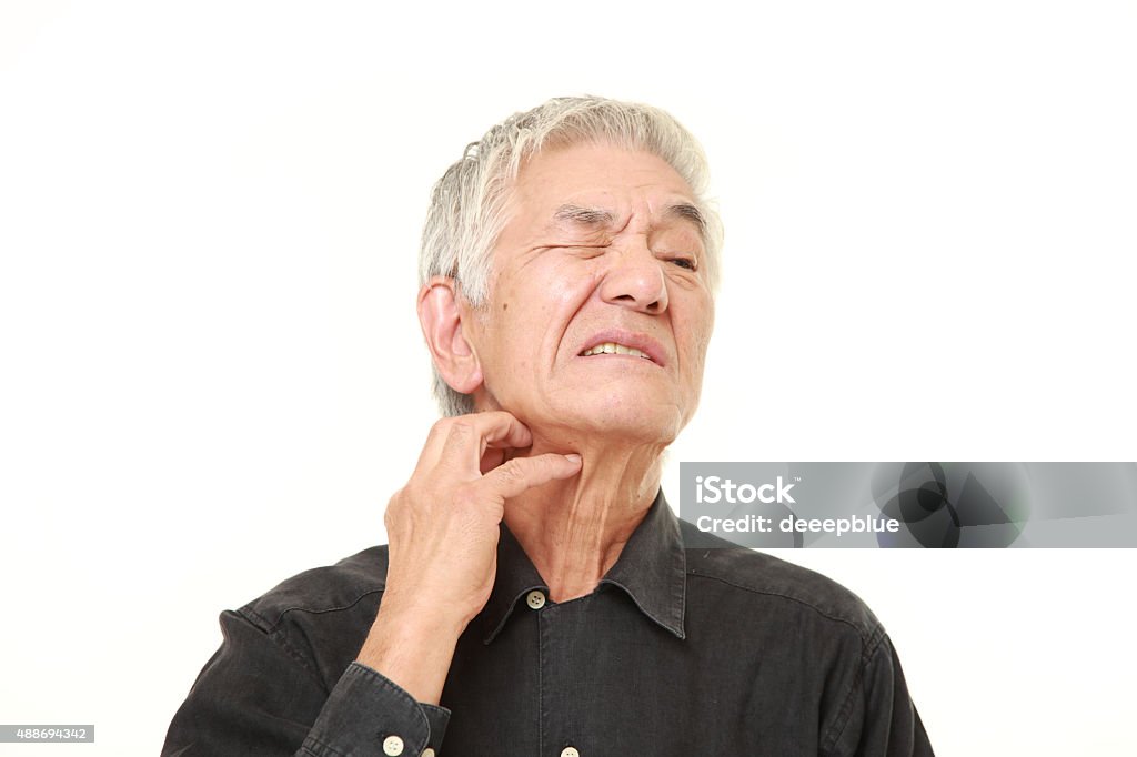 senior Japanese man scratching his neck studio shot of senior Japanese man on white background Scratching Stock Photo