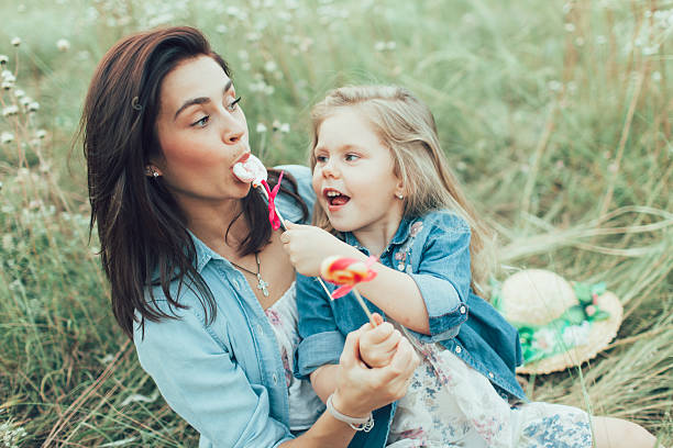 istock The young mother and daughter on green grass background 488708432