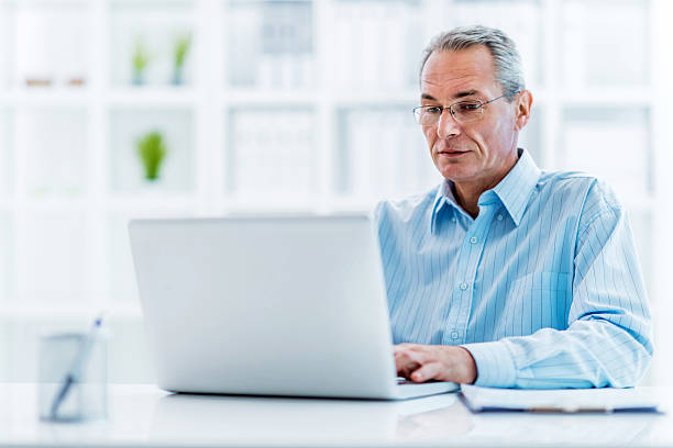 istock Mature businessman using laptop in the office. 488709672