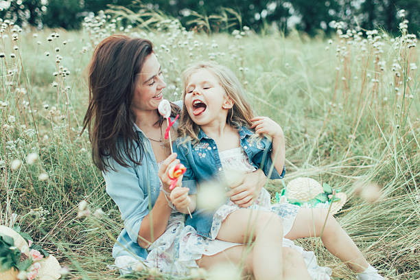 istock The young mother and daughter on green grass background 488710868