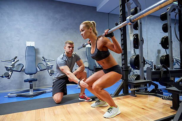 istock man and woman with bar flexing muscles in gym 488715046
