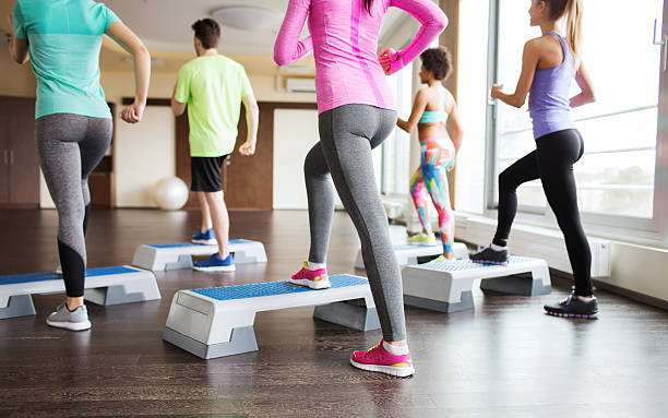 primo piano di persone al lavoro con gli stepper in palestra - passo foto e immagini stock