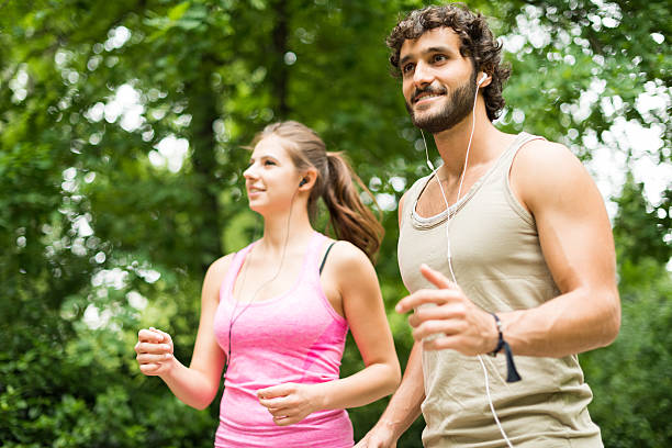 istock Smiling happy couple running in a park 488717432