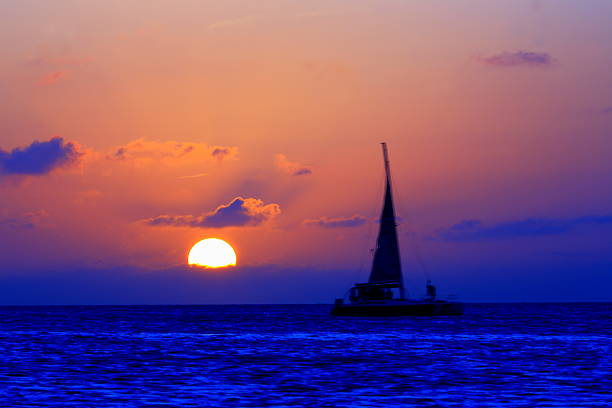 turquoise des caraïbes plage paradisiaque, voilier, soleil coucher de soleil spectaculaire - sailing sailboat sunset aruba photos et images de collection