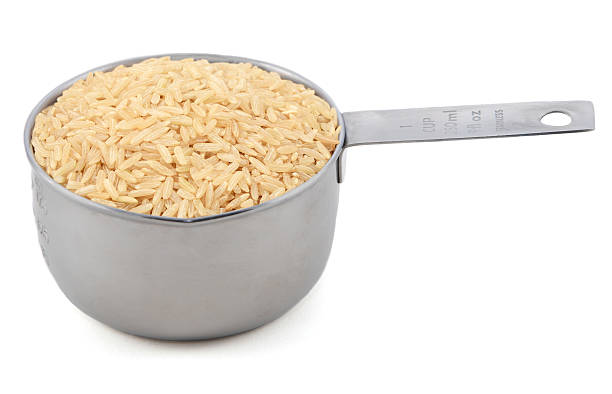 Largo grano arroz integral en un recipiente para medir - foto de stock