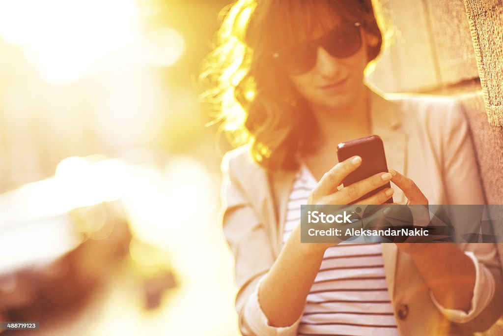 Using a smartphone outdoors Businesswoman using a smartphone outdoors 25-29 Years Stock Photo