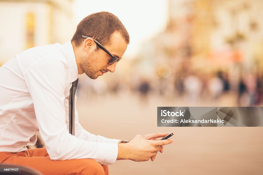 Using a smartphone on the street Businessman using a smartphone on the street 25-29 Years Stock Photo