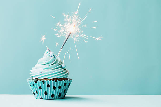 Cupcake with sparkler Cupcake with sparkler against blue birthday cake photos stock pictures, royalty-free photos & images