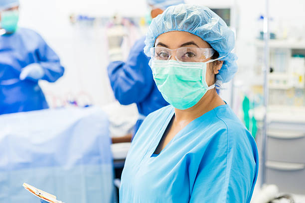 hispânico cirurgia enfermeira ajuda os cirurgiões no hospital sala de operações - urgency body care young adult people imagens e fotografias de stock