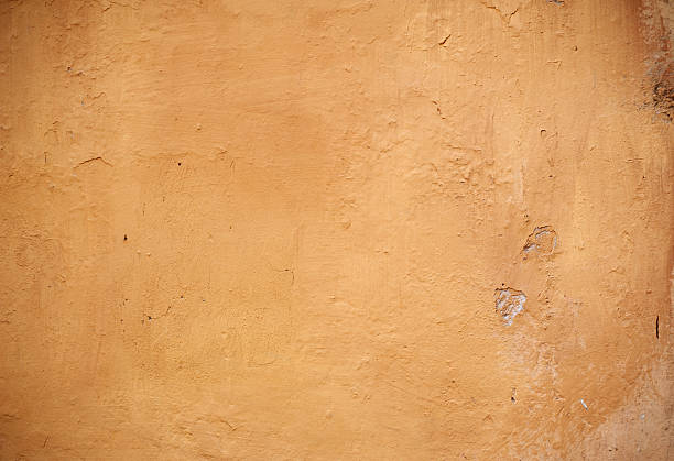 istock Texture of old wall covered with yellow stucco 488721550
