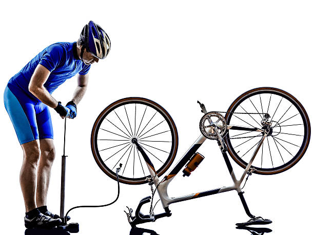 istock cyclist repairing bicycle silhouette 488721921