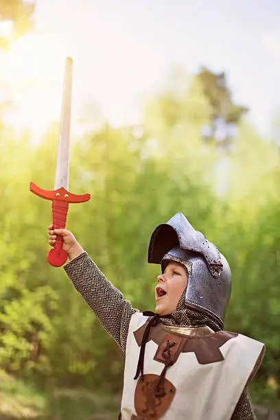 Little knight rising his sword after winning a battle.