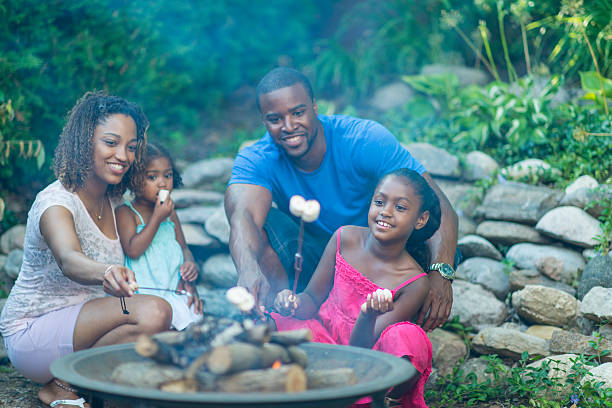 Roasting Marshmallows Family roasting marshmallows over a camp fire. staycation photos stock pictures, royalty-free photos & images