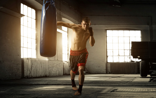 Young man boxing workout in an old building