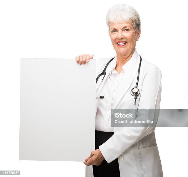 Cheerful Latin Doctor Holding A Sign Stock Photo - Download Image Now - 70-79 Years, Active Seniors, Adult