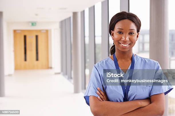 Portrait Of Female Nurse Standing In Hospital Corridor Stock Photo - Download Image Now