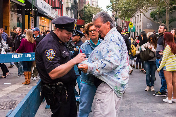New York, USA - September 20, 2014: NYPD officer has fun with tourists as crowds gather to celebrate the annual festival of San Gennaro, New York. 