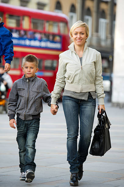 istock Young Mother Walking With Son In The City 488758575