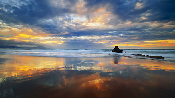 istock clouds reflections in Sopela beach at sunset 488758578