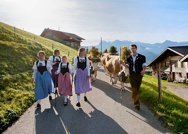 スイス農家の伝統的な服装でご家族のウォーキングダウン山 - switzerland cow bell agricultural fair agriculture ストックフォトと画像