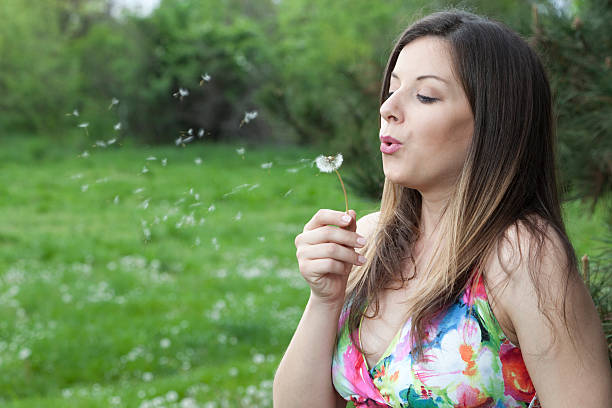 istock Pregnant woman blowing dandelion. 488758955