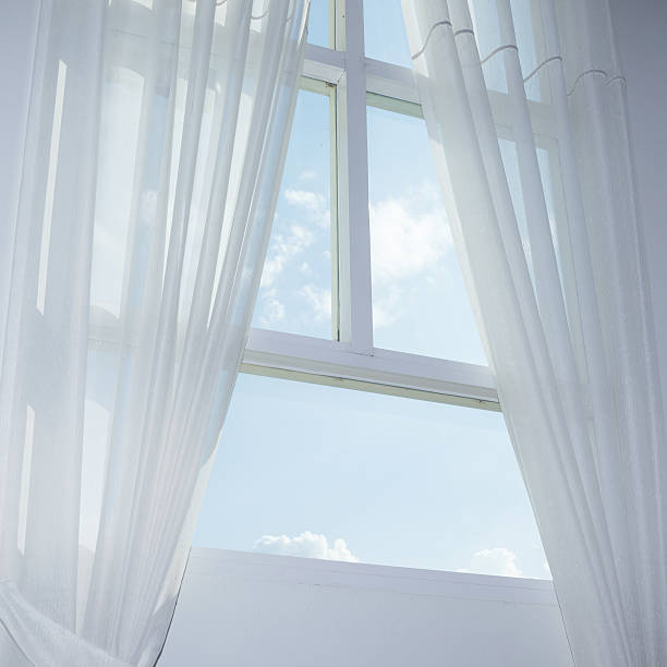 istock white curtain on the window with blue sky 488759476