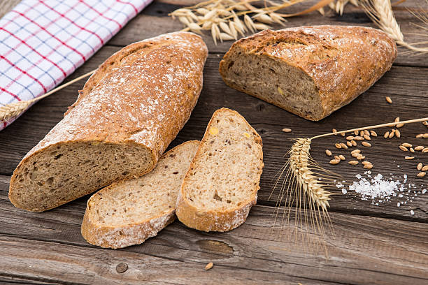 istock Rustic bread and wheat on vintage planked wood table. 488760976