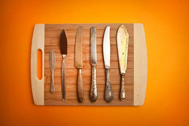 Vintage knives on wooden chopping board