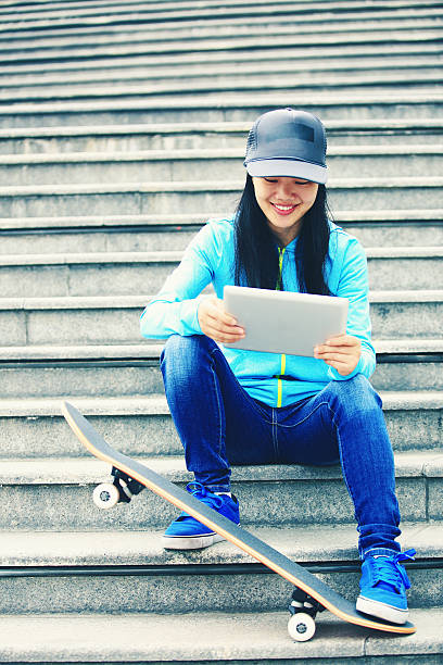 istock young woman skateboarder use her digital tablet sit on stairs 488761309