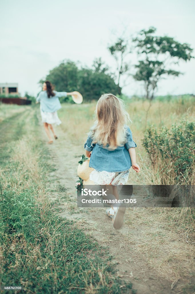 The young mother and daughter on green grass background The back view of young mother and daughter on green grass background.   2015 Stock Photo