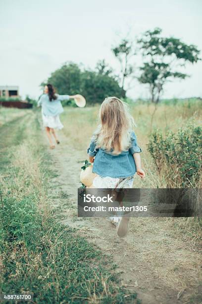 The Young Mother And Daughter On Green Grass Background Stock Photo - Download Image Now