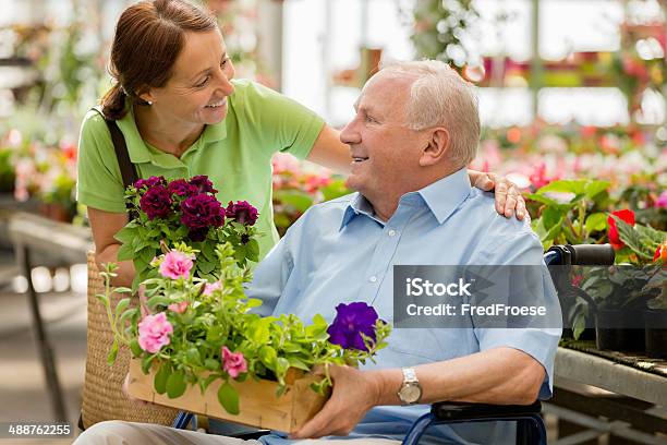 Caregiver And Senior Man At A Garden Center Assisted Living Stock Photo - Download Image Now